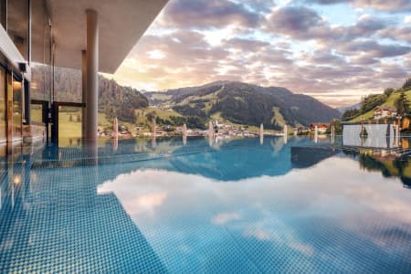 Malerische Alpenkulisse und der Pool des Resorts Das Edelweiss.